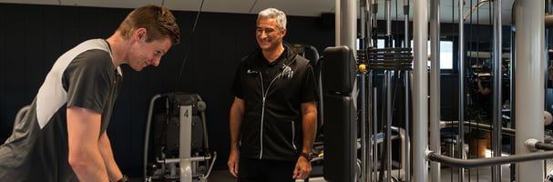 Person training on exercise equipment with Oddvar who owns Spenst next to him