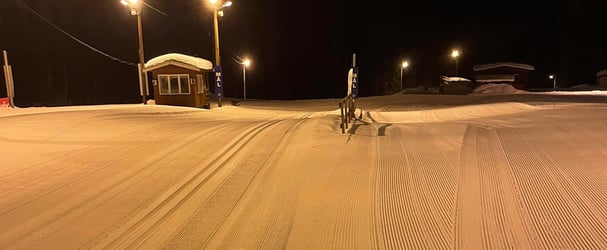 Evening photo of a floodlit trail at the stadium, with floodlights and newly prepared tracks
