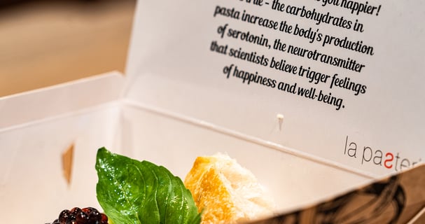 Pasta dish as takeaway in a box with greetings from the restaurant