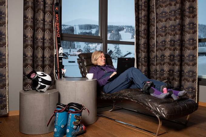 Lady in ski clothes has home office at the cabin