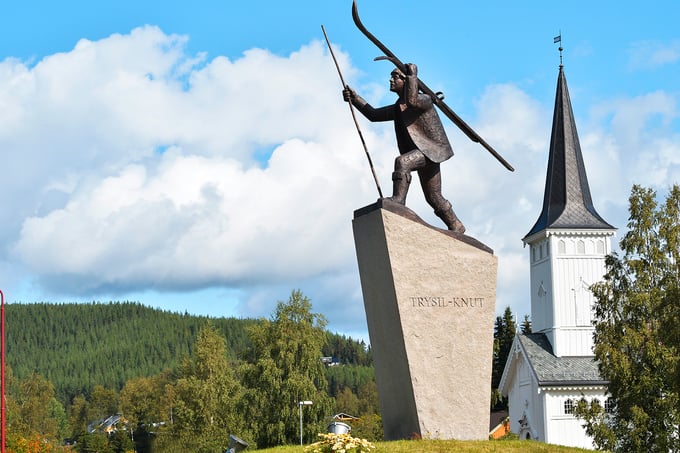 Trysil-Knut statue med Trysil kirke i bakgrunn