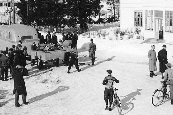 At "Krysset" in Nybergsund on the morning of 11 April 1940. A bus is filled with mobilized people who are going to meet in Elverum. Three of them are killed in the bomb attack on Elverum. On the way, we can see some of those who fled here on 9 and 10 April.